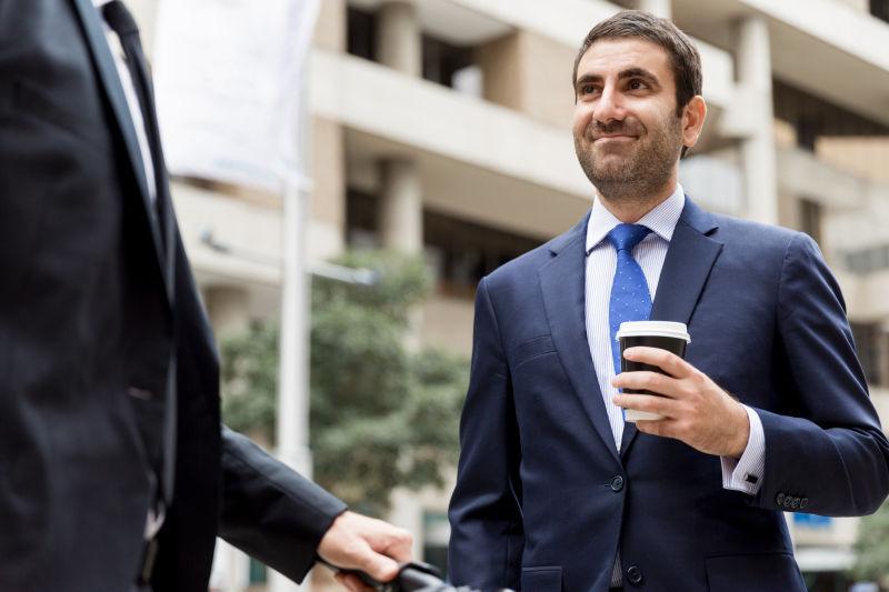 城市建筑背景下在市中心骑自行车的两位年轻商人