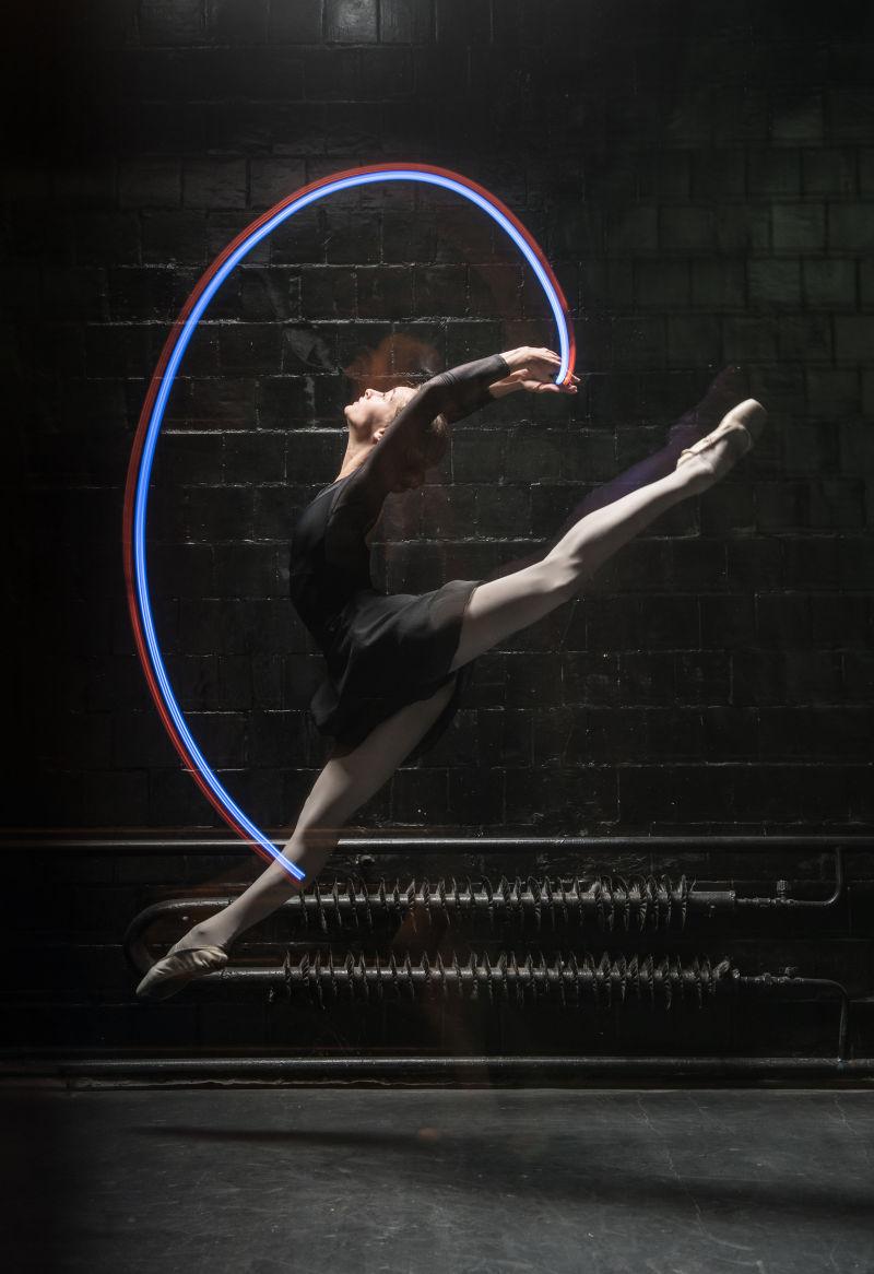 优雅的芭蕾舞演员用彩带跳跃