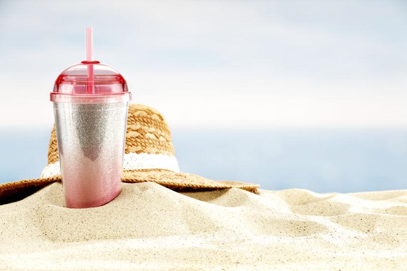 一部可乐和草帽在沙滩上