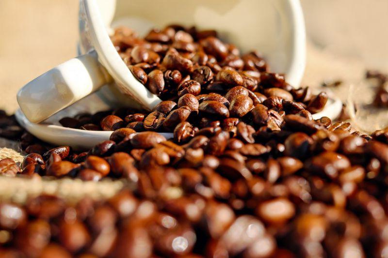 白色咖啡杯里洒落出来的咖啡豆