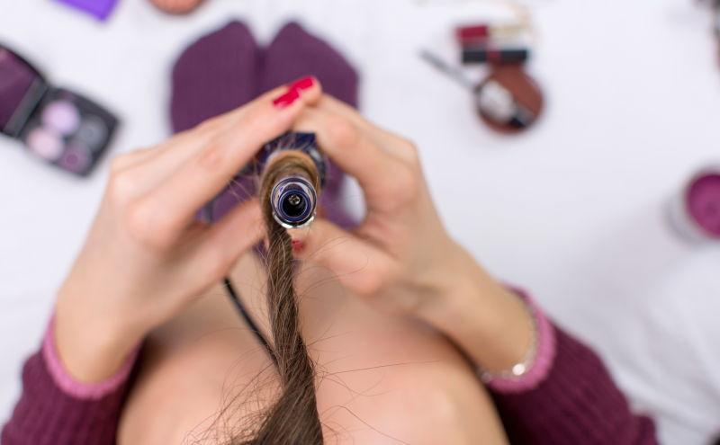 女人在用卷发棒烫卷头发