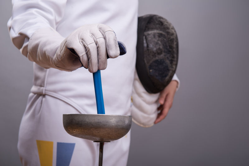 击剑运动员拿着击剑头盔与剑