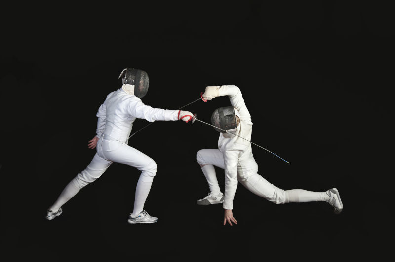 黑色背景下的两名击剑运动员