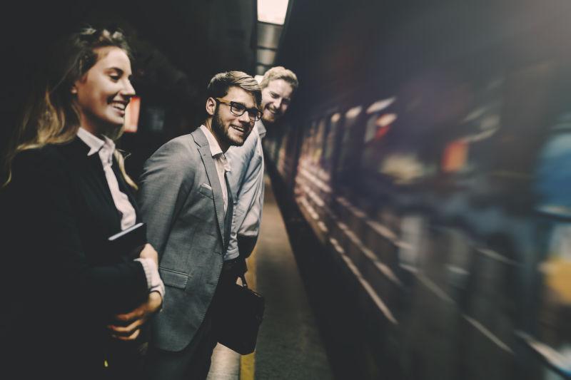 快速通过的地铁旁等待地铁的商界人士