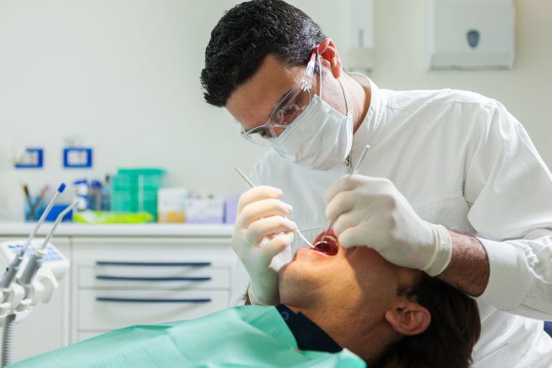 正在为患者检查牙齿的牙医