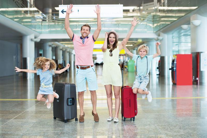 带着行李箱旅游的快乐家庭