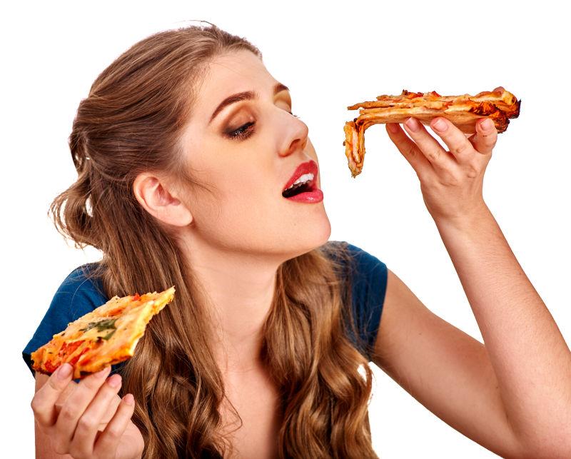 白色背景下年轻漂亮的美女正在吃披萨