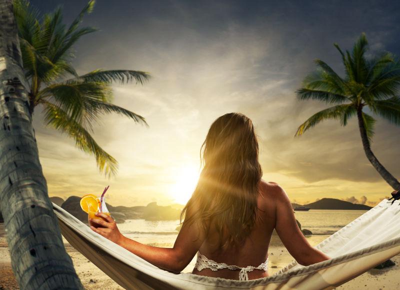 日落时分吊床上的年轻美女