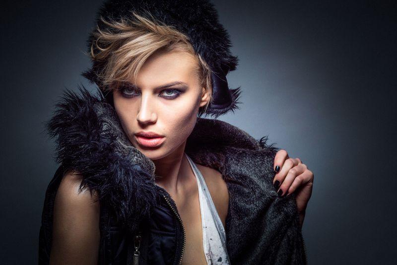 暗色背景上拉着衣领的金发女郎