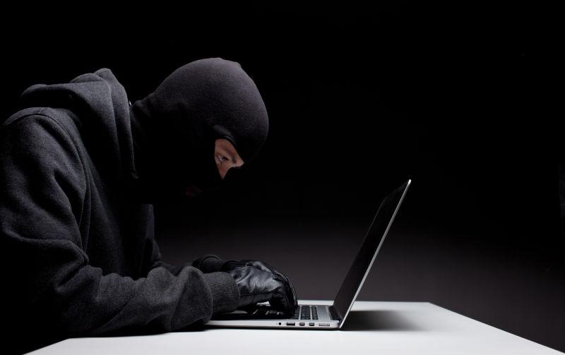 操作电脑戴着手套窃取信息的黑客