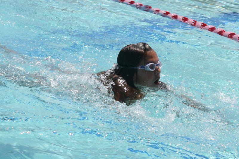 小女孩在游泳池里游泳