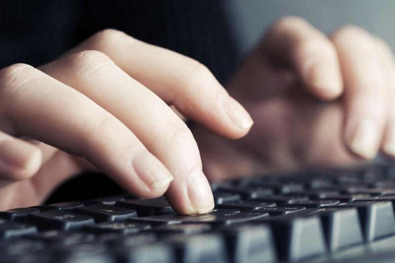 女人的手放在电脑键盘上打字