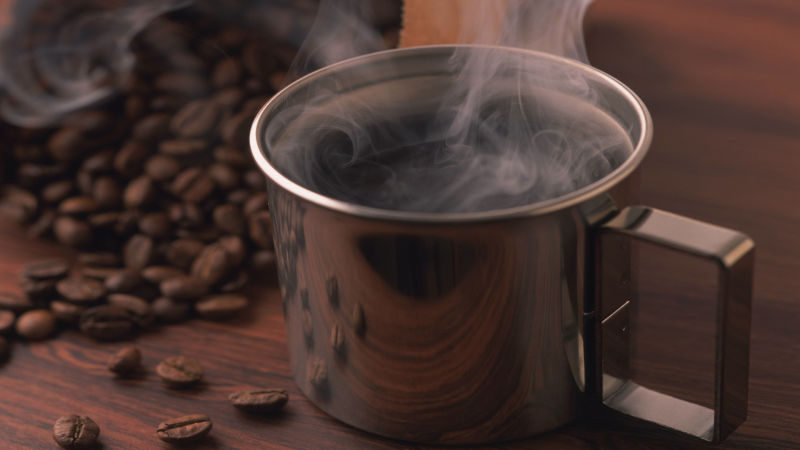 一杯热气腾腾的热咖啡与咖啡豆