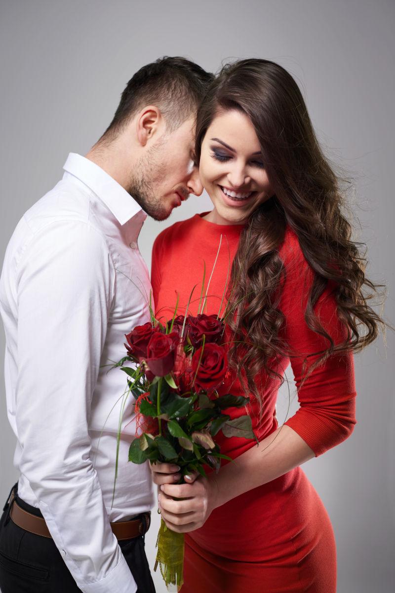 女人拿着男人送给她的红色玫瑰花