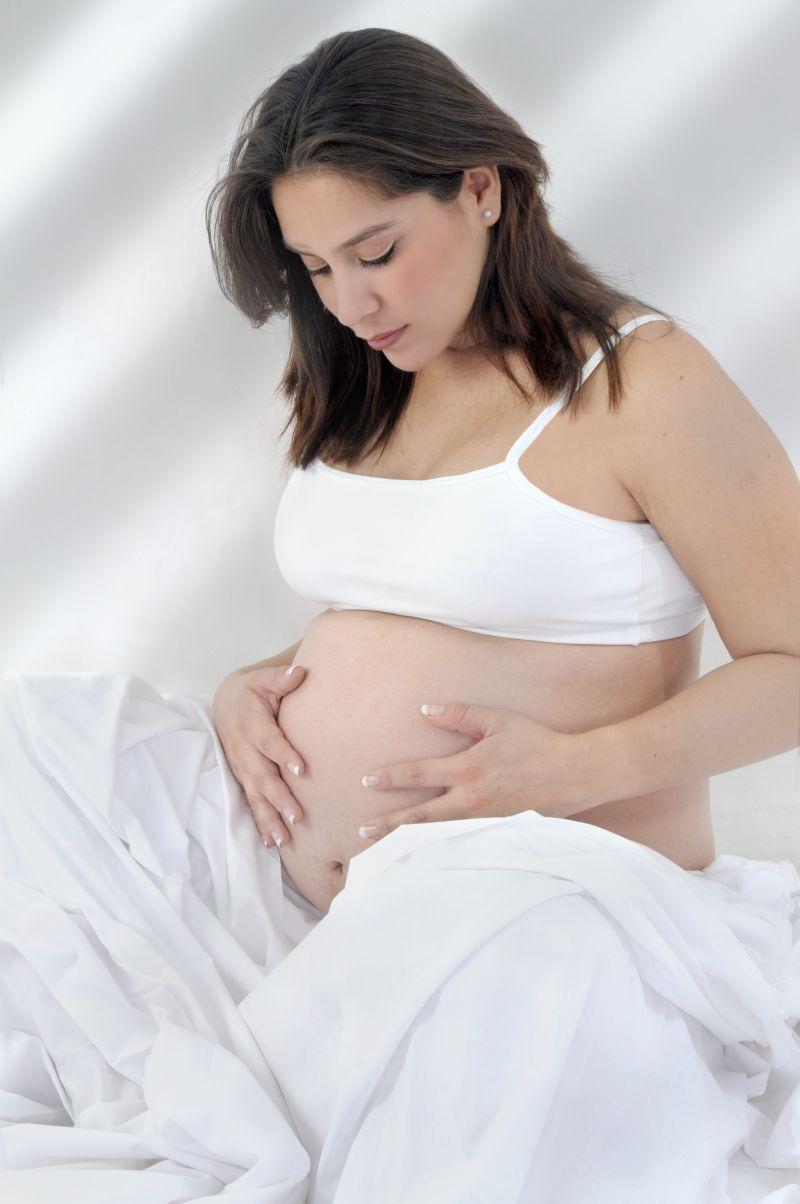正在低头看肚子的怀孕的孕妇