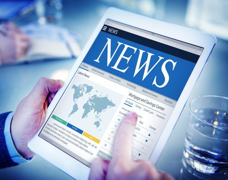 拿着平板电脑看最新新闻的商人