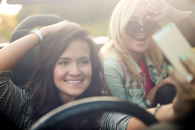 两位积极漂亮的旅行者带着手机摄像头自拍