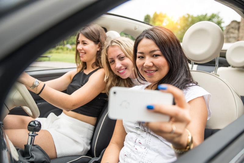 三位美女坐在敞篷车上自拍