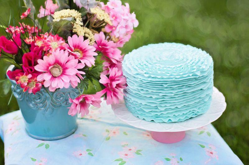 桌子上的花和蓝色奶油蛋糕