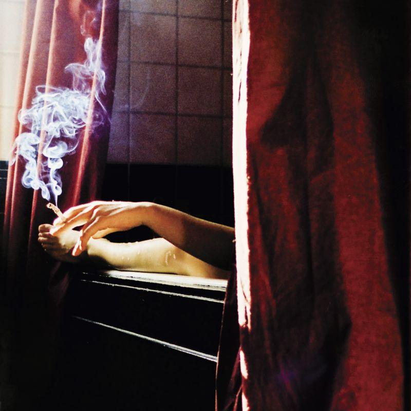 正在卧室吸烟的成年男子