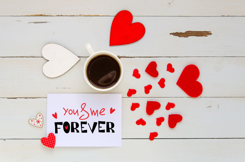 情人节旧式装饰木制背景下的心灵和咖啡杯