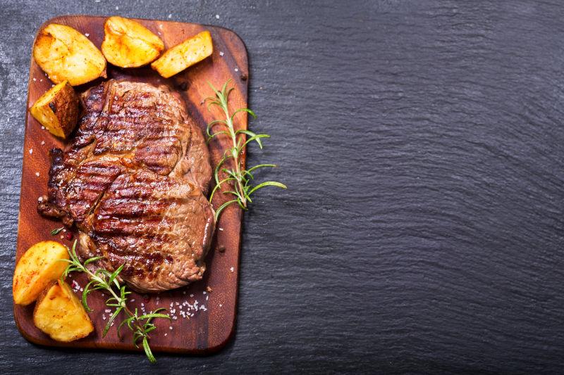 黑色木桌上的美味烤牛排