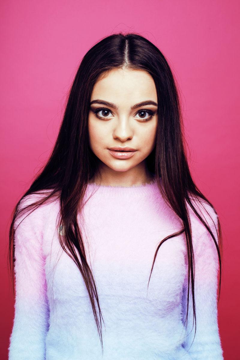 粉红色背景下的年轻漂亮的少女