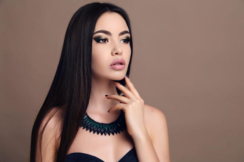 拥有鲜艳的妆容和项链的美丽性感的女人