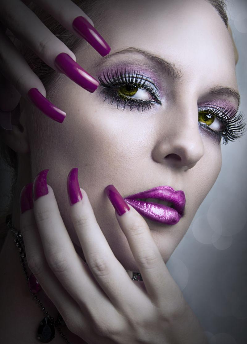 美丽的女人时尚炫彩晚上弥补和修指甲美容紫色的指甲的画像