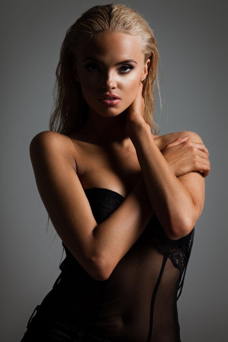 灰色背景下迷人的金发美女