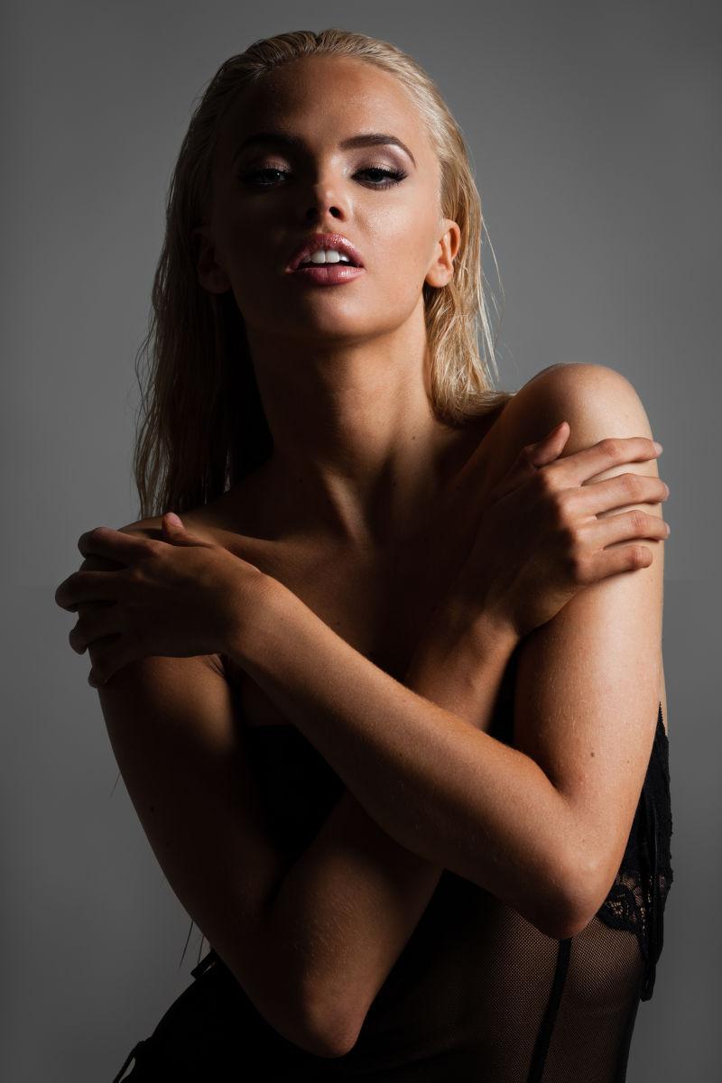 灰色背景下的自然美丽的金发女性