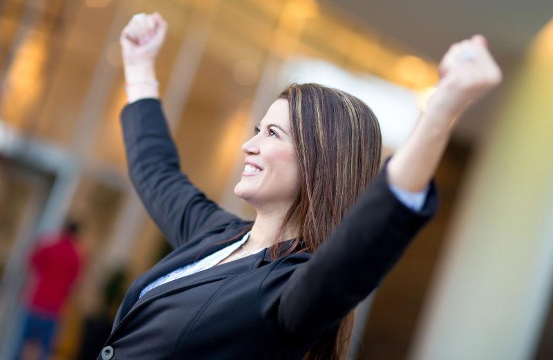 穿着黑色西装的美女在握拳庆祝