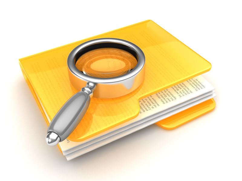 黄色文件夹上放着一个放大镜