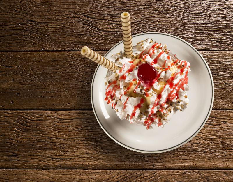 木板上的白色盘子里放着美味的冰淇凌