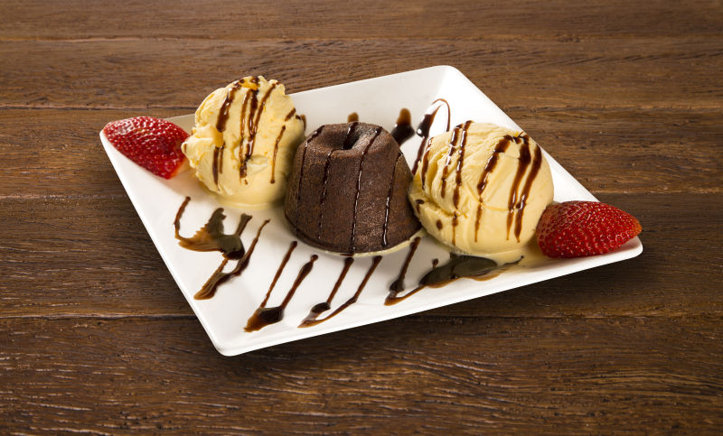 白色盘子里的美味冰淇凌球和草莓