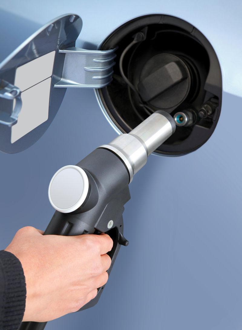 拿着加油枪给汽车加油