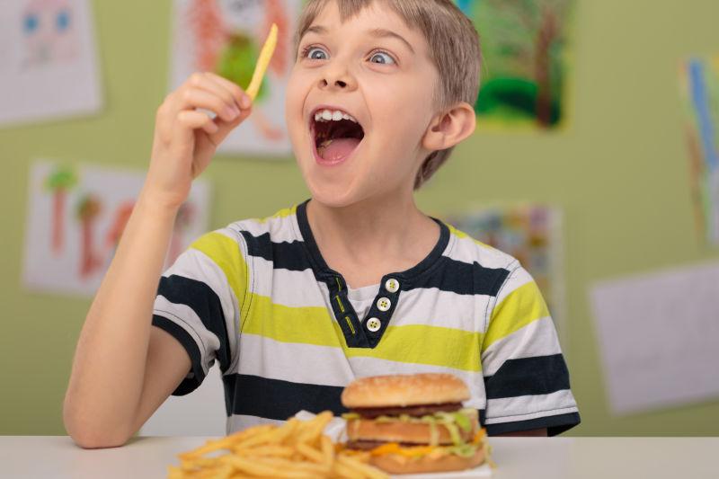 快乐的男孩在学校吃薯条