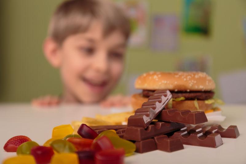 微笑的男孩享受他不健康的学校午餐