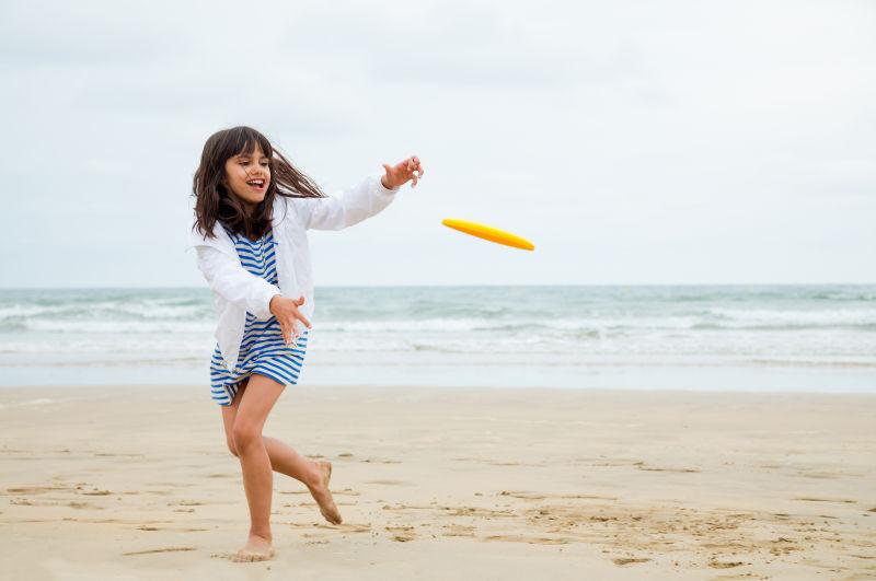在云天的海滩上玩耍的一个小女孩