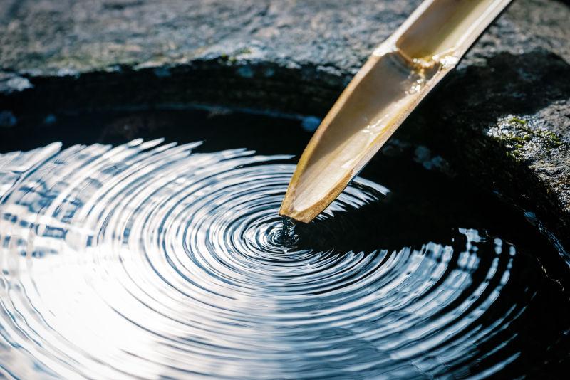 水流通过竹筒在往水潭里注水