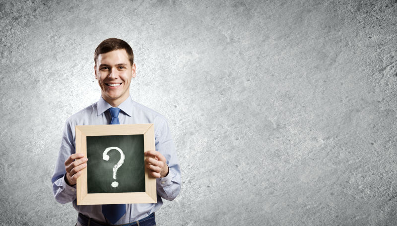 灰色背景下拿着问号黑板的商人