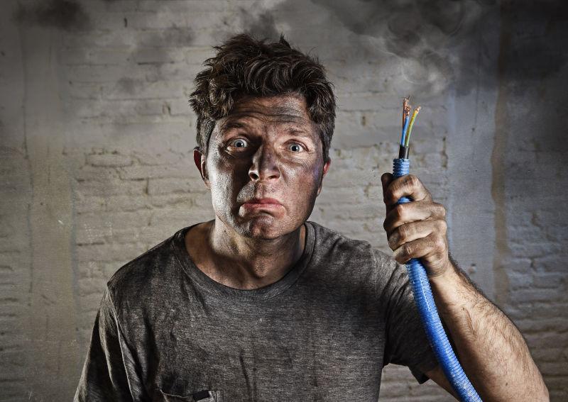 年轻人拿着电缆冒烟