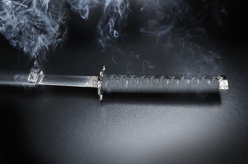 黑背景中有烟雾的尖刀