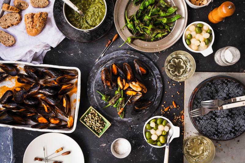 黑色桌上有烤蔬菜和海鲜的晚餐