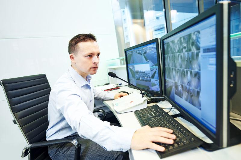 监控室里查看视频监控的男人