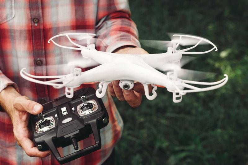 男人拿着无人机和遥控器