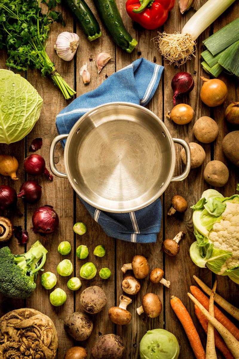 古朴的原始木材为背景的烹调空罐与秋季蔬菜周围