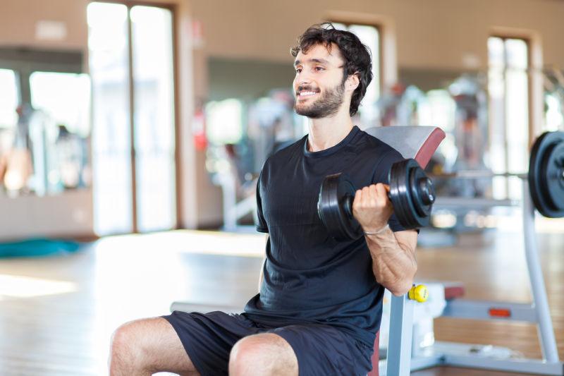 健身房里在用哑铃锻炼肌肉的男人