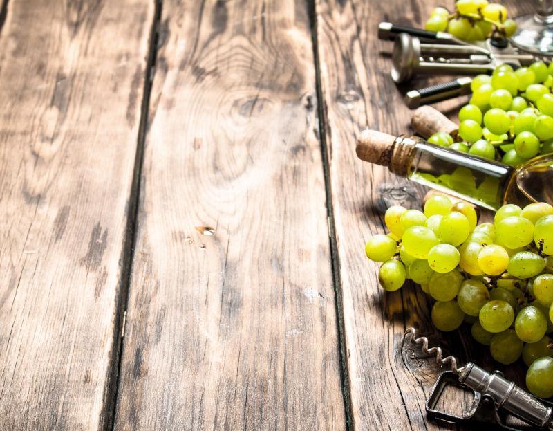 木板上的白葡萄酒和葡萄