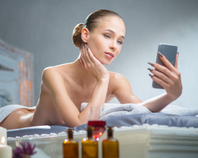 水疗中心的美女在智能手机上拍照